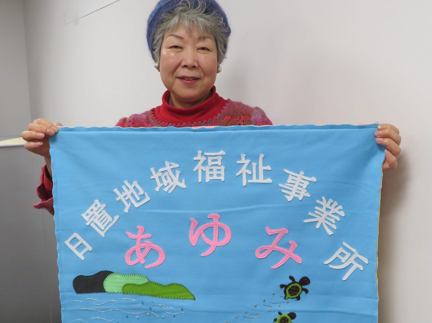 直鞍事業所庄野さん　日置あゆみに9作目　事業所誕生祝いにタペストリー 　　